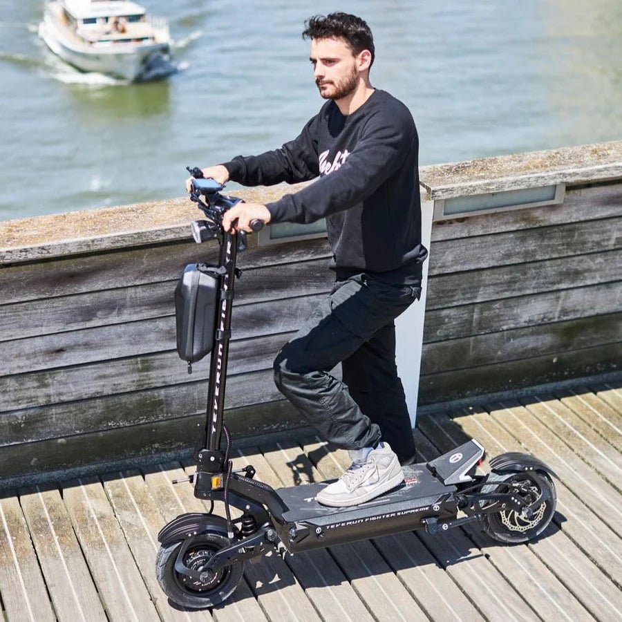 Hombre de pie junto al patinete eléctrico TEVERUN FIGHTER SUPREME ULTRA V4