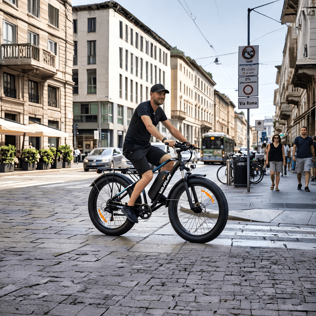 Hombre montando la bicicleta eléctrica fat bike VARUN M26-2 Plus en color negro por la ciudad