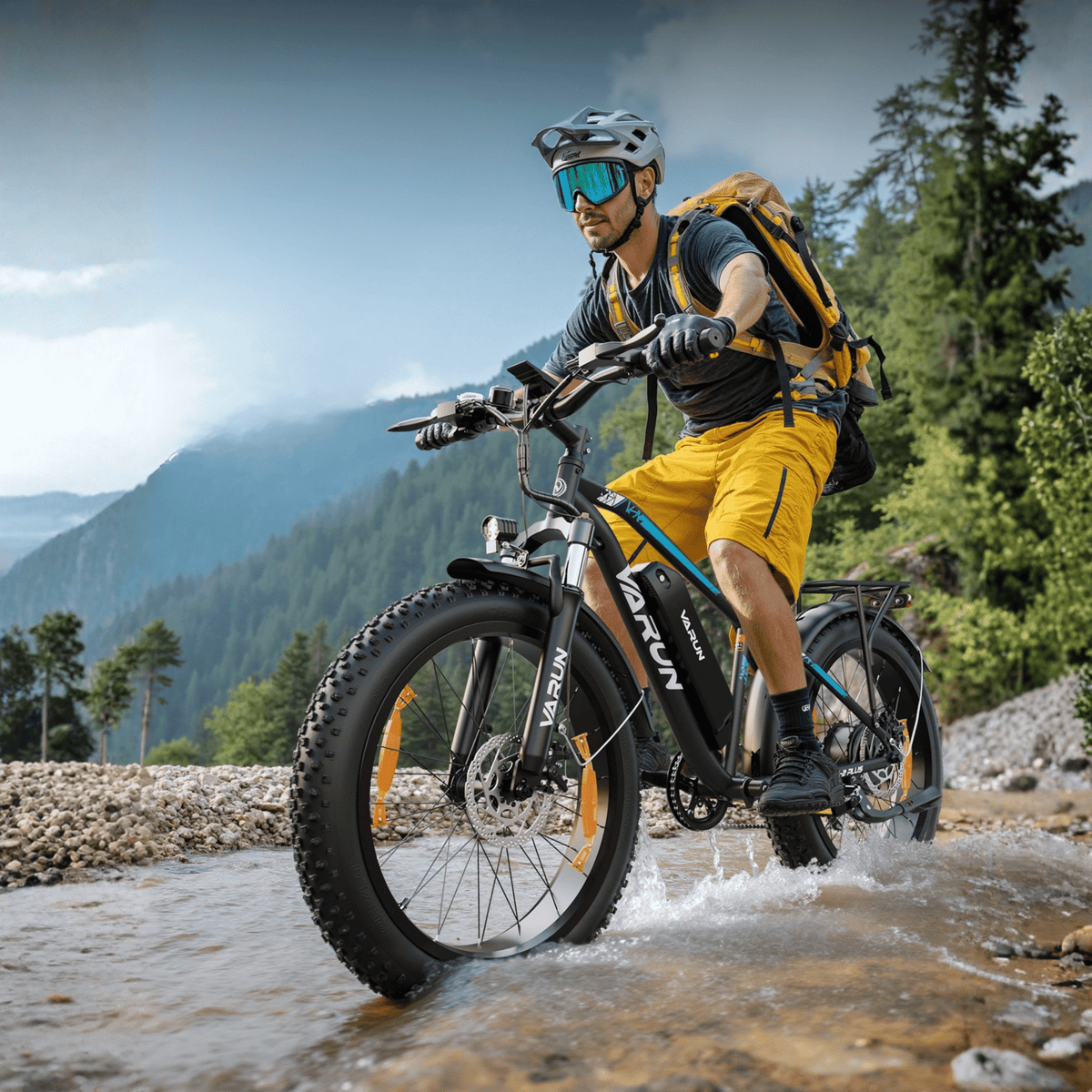 Piloto con la bicicleta eléctrica fat bike VARUN M26-2 Plus fuera de pista con casco en la montaña