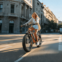 Mujer montando la bicicleta eléctrica fat bike VARUN M26-2 Plus en color naranja por la ciudad