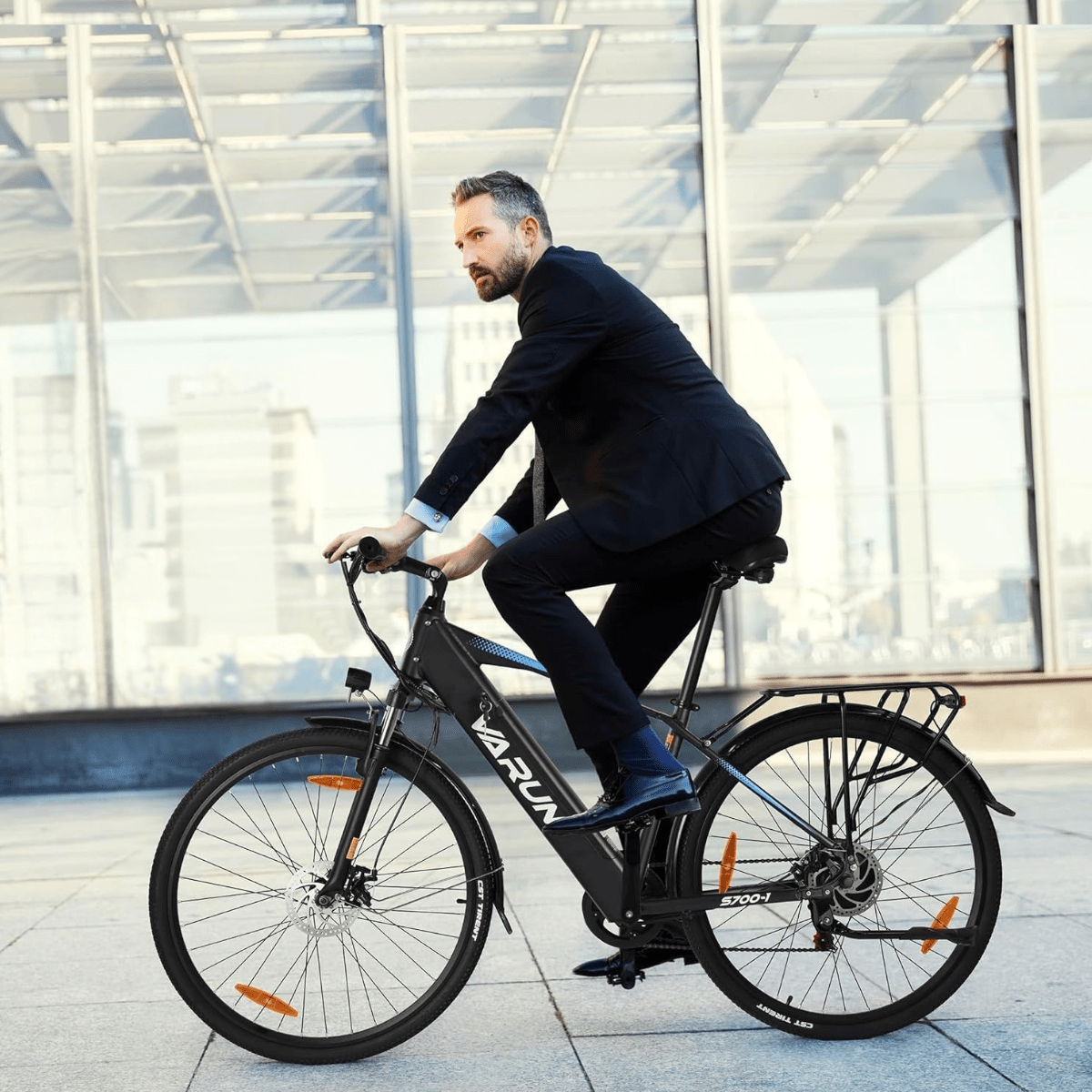 Hombre montando la bicicleta eléctrica VARUN S700-1 en color negro por la ciudad
