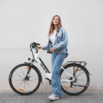 Mujer de pie junto a la bicicleta eléctrica VARUN S700-2 en color blanco sobre fondo blanco
