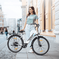 Mujer de pie junto a la bicicleta eléctrica VARUN S700-2 en color blanco en la ciudad