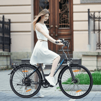 Mujer montando la bicicleta eléctrica VARUN S700-2 en color negro por la ciudad