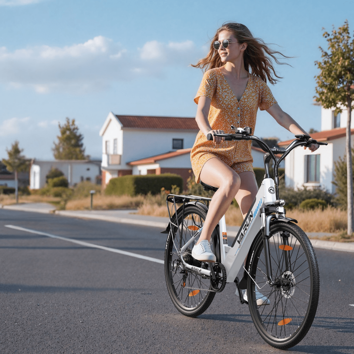 Mujer montando la bicicleta eléctrica VARUN S700-2 en color blanco por una calle