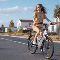 Mujer montando la bicicleta eléctrica VARUN S700-2 en color blanco por una calle