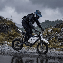 Piloto con la moto cross eléctrica Vipcoo H2 fuera de pista por la carretera