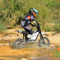 Piloto con la moto cross eléctrica Vipcoo H2 fuera de pista sobre terreno arenoso
