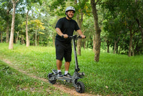 Hombre de pie junto al patinete eléctrico VIPCOO VS9 en un parque