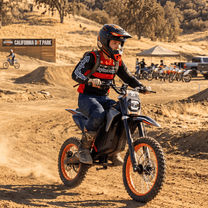 Persona montando la moto cross eléctrica Wheely Y88 sobre terreno arenoso