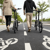 Dos personas con la bicicleta eléctrica plegable YANGOR H19 en color gris por un camino peatonal
