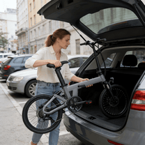 Mujer de pie junto a la bicicleta eléctrica plegable YANGOR H19 en color gris